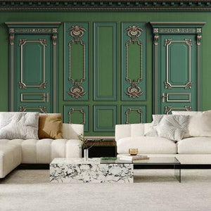 Könnte beinhalten: Ein Wohnzimmer mit einer grünen Wand mit verzierten Tür- und Paneeldesigns in Gold und Grün. Weiße Sofas und ein Marmor-Couchtisch stehen auf einem hellen Teppich. Zierleisten schmücken die Oberseite der Wand.