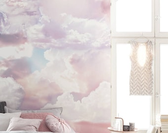 Könnte beinhalten: Ein Schlafzimmer mit einer rosa-weißen Wolkentapete, einem Bett mit weißen und rosa Kissen, einem Nachttisch mit einer Lampe und einem Fenster mit einem weißen Kleid, das daran hängt.
