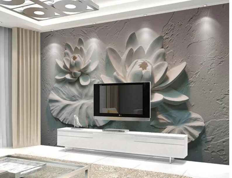 K&ouml;nnte beinhalten: Eine wei&szlig;e 3D-Wandmalerei mit einer gro&szlig;en, stilisierten Lotusblume auf einem strukturierten, grauen Hintergrund. Ein Flachbildfernseher ist unterhalb der Wandmalerei an der Wand montiert.
