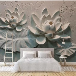 K&ouml;nnte beinhalten: Eine wei&szlig;e 3D-Wandmalerei mit zwei gro&szlig;en wei&szlig;en Lotusblumen mit Bl&auml;ttern. Die Blumen sind modelliert und scheinen an der Wand zu schweben.