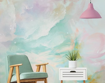 Könnte beinhalten: Ein grüner Sessel mit Holzbeinen steht vor einem weißen Beistelltisch mit einer Schublade. Die Wand hinter den Möbeln ist mit einem Aquarell-artigen abstrakten Design in Rosa-, Blau- und Grüntönen bemalt.