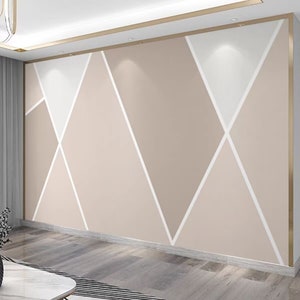 Può includere: Un muro con un motivo geometrico di triangoli bianchi e beige. Il muro è dipinto di un colore beige chiaro e i triangoli sono contornati di bianco.