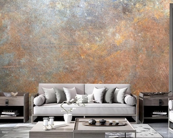 Könnte beinhalten: Ein Wohnzimmer-Interieur mit einem hellgrauen Sofa mit Kissen und einem Couchtisch davor. Die Wand hinter dem Sofa ist eine strukturierte Tapete mit einem rostigen Metallaussehen in Braun-, Grau- und Gelbtönen.