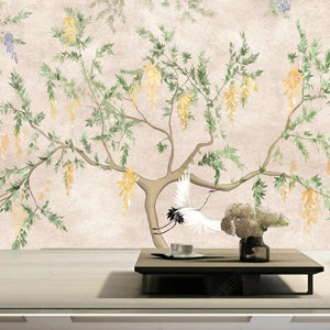 May include: A watercolor painting of a tree with yellow flowers and two white cranes in flight. The painting is on a beige background and is framed by a wooden frame.