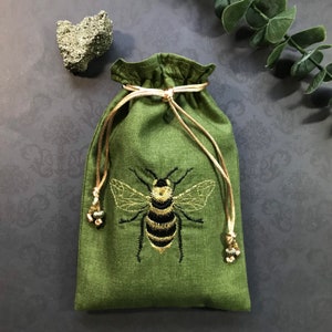 Bolsa con cordón con abeja bordada en negro y dorado, hecha a mano, forrada de seda