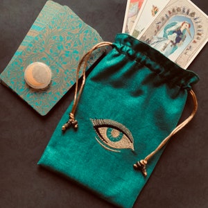 Bolsa con cordón y ojo dorado bordado, hecha a mano, forrada de seda