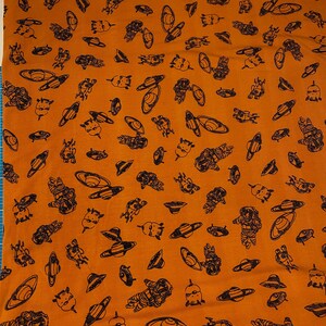 Könnte beinhalten: Orangener Stoff mit einem sich wiederholenden Muster aus schwarzen Astronauten- und Planetenillustrationen.