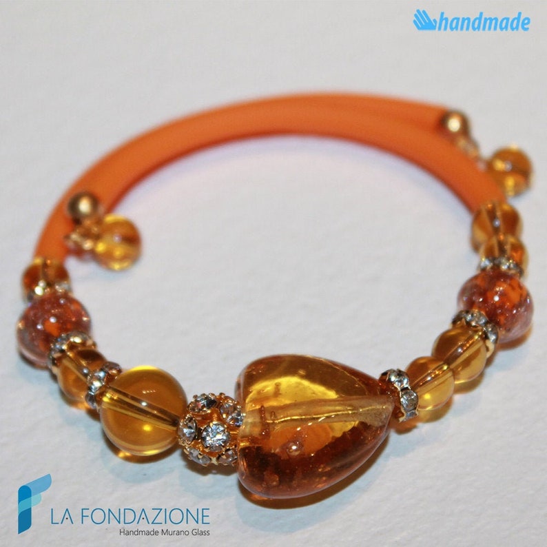 May include: A handmade orange elastic bracelet with amber glass beads and a large heart-shaped amber glass bead with clear rhinestones.