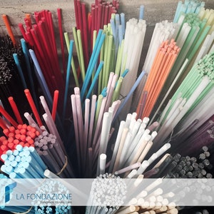 May include: Assortment of colorful glass rods for crafting. The rods are bundled together and arranged in a variety of colors, including red, blue, green, white, and black. The rods are all approximately the same size and are perfect for creating jewelry, mosaics, and other art projects. The image includes the text "LA FONDAZIONE Handmade Murano Glass".