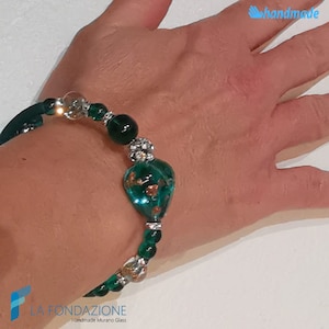 May include: A green glass heart charm bracelet with silver beads and a clear glass bead. The bracelet is handmade and features a green glass heart with gold flecks.