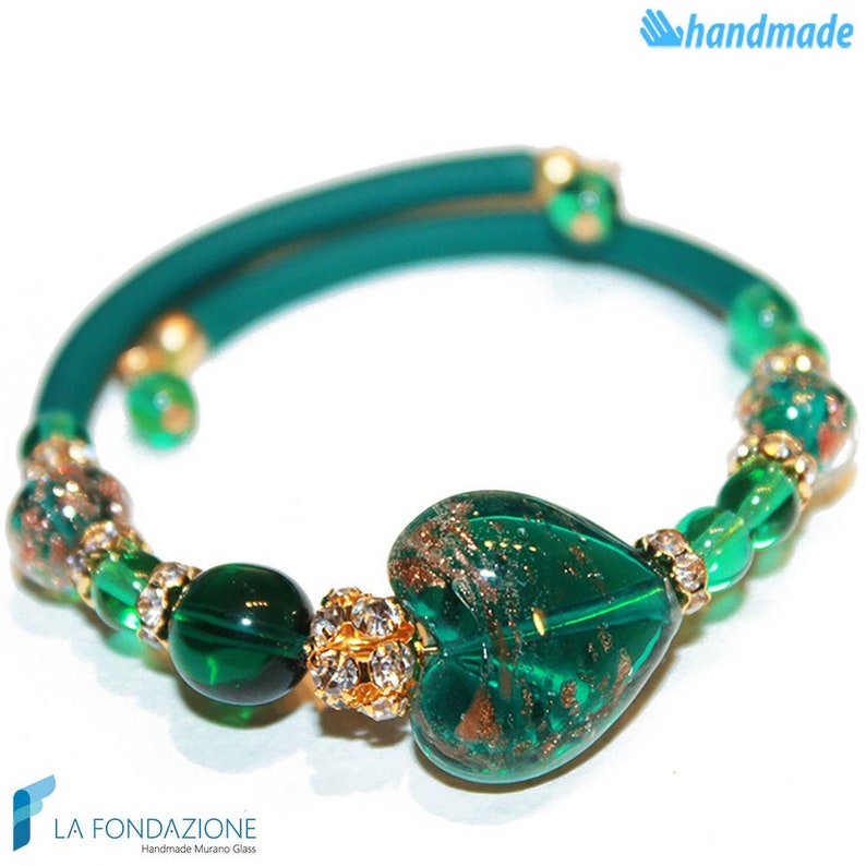 May include: A green glass heart charm bracelet with gold accents and a green leather cord. The heart charm has gold flecks and is surrounded by smaller green glass beads.