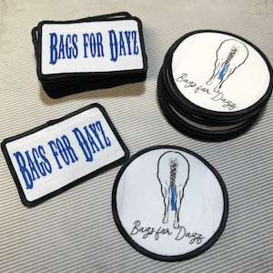 May include: A collection of patches with the text "BAGS FOR DAYZ" in blue on a white background, and round patches with a horse's rear illustration and the text "Bags for Dayz". The patches have black borders.