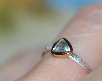 Silver ring with blue aquamarine zircon in a gold-plated setting, oldest mineral on earth, philosopher's stone