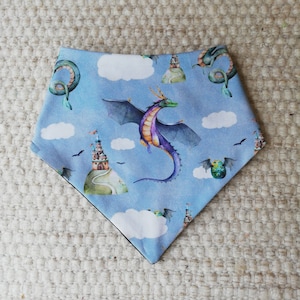 Könnte beinhalten: Ein blaues Bandana mit einem Drachen-, Schloss- und Wolkenmuster. Das Bandana ist aus weichem, bequemem Stoff und perfekt für den täglichen Gebrauch.