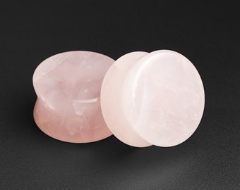 May include: Two pink rose quartz ear gauges, one slightly larger than the other, with a smooth, polished finish.