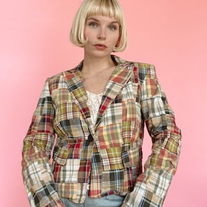 May include: A patchwork blazer with a mix of red, green, yellow, and blue plaid patterns. The blazer has a single button closure and a fitted silhouette.