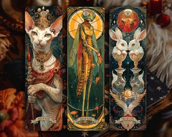 Könnte beinhalten: Drei Tarot-Lesezeichen mit einzigartigen Illustrationen. Eines zeigt eine königliche Katze, ein anderes ein humanoides Insekt und das letzte zwei Kaninchen. Jede Karte trägt einen anderen Titel: "Queen of Wands", "Page of Wands" und "Two of Cups".