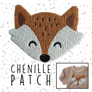 Könnte beinhalten: Ein brauner und weißer Chenille-Fuchs-Patch mit einem lächelnden Gesicht. Der Patch trägt den Schriftzug "Chenille Patch" in schwarzer Schrift.