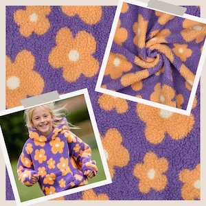 Könnte beinhalten: Ein lila-orangefarbener Kapuzenpullover mit Blumenmuster aus strukturiertem Fleece-Stoff. Das Muster zeigt große, stilisierte fünfblättrige Blumen mit weißen Zentren, die sich auf dem Material wiederholen. Das Kleidungsstück hat eine Kapuze.