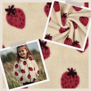 Könnte beinhalten: Eine cremefarbene Fleecejacke mit einem sich wiederholenden Muster aus roten Erdbeeren mit dunkelbraunen Stielen. Der Stoff hat eine strukturierte, flauschige Oberfläche. Die Jacke verfügt über einen Frontreißverschluss, lange Ärmel und eine Kapuze.