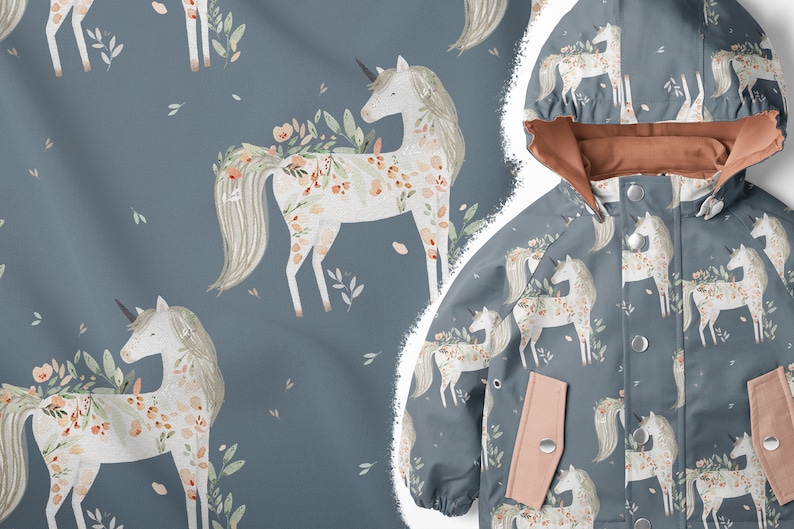 K&ouml;nnte beinhalten: Eine blaue Kinderjacke mit einem wei&szlig;en Einhornmuster. Das Einhorn ist von Blumen und Bl&auml;ttern umgeben. Die Jacke hat ein rosafarbenes Futter und eine Kapuze.