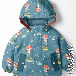 Puede incluir: Una gabardina azul para ni&ntilde;os con un patr&oacute;n de setas y lluvia. La gabardina tiene capucha y dos bolsillos. El patr&oacute;n presenta un personaje de dibujos animados sosteniendo un paraguas de seta.