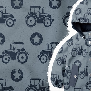 Può includere: Una giacca blu con cappuccio con un motivo ripetuto di trattori blu e stelle su uno sfondo grigio.