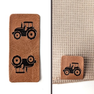 Op de afbeelding: Twee bruine leren patches met zwarte tractoren silhouetten. Eén patch is rechthoekig en heeft twee tractoren, terwijl de andere vierkant is en één tractor laat zien.