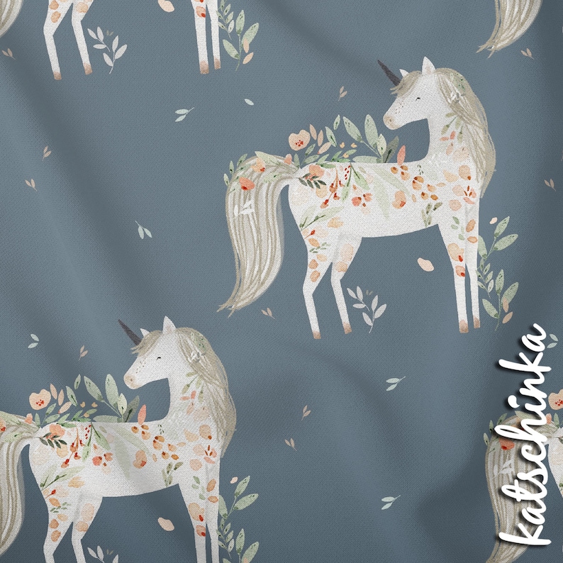 K&ouml;nnte beinhalten: Ein nahtloses Muster mit wei&szlig;en Einh&ouml;rnern mit floralen Details auf blauem Hintergrund. Die Einh&ouml;rner haben flie&szlig;ende M&auml;hnen und Schw&auml;nze, und die Blumen sind in Rosa-, Orange- und Gr&uuml;nt&ouml;nen.