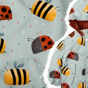 Op de afbeelding: Een blauwe en witte stof met een herhalend patroon van gele en zwarte bijen en rode en zwarte lieveheersbeestjes. De stof is te zien op een jas met een rode capuchon.