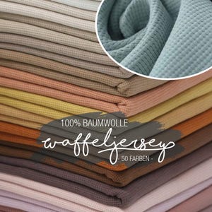Könnte beinhalten: Stapel von Waffelstrickstoffmustern in verschiedenen Farben, darunter Beige, Pfirsich, Gelb und Braun. Eine Nahaufnahme zeigt die Textur und ein blau-grünes Stoffstück. Text: "100% Baumwolle" und "Waffeljersey - 50 Farben".