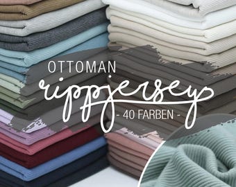 Op de afbeelding: Een stapel verschillende gekleurde ribgebreide jersey stofstalen. De stof is gelabeld "Ottoman rippjersey - 40 Farben - "