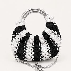 Peut inclure: Un sac à main en forme de croissant réalisé en fil crocheté noir et blanc avec un motif à rayures verticales. Le sac présente une poignée circulaire en métal argenté sur le dessus et une bandoulière en chaîne métallique argentée.