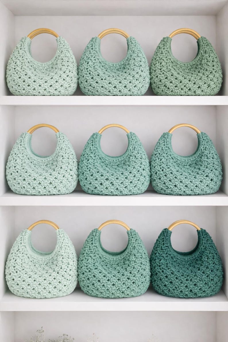 May include: Nine crocheted handbags arranged on shelves, each featuring a rounded wooden handle and a textured, open-weave pattern. The bags are displayed in a gradient of green shades, ranging from pale mint to deep forest green, with a consistent crescent shape.