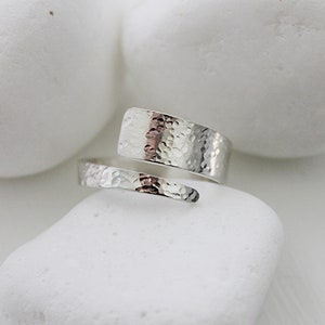 May include: A silver hammered metal ring with a unique wrap-around design.