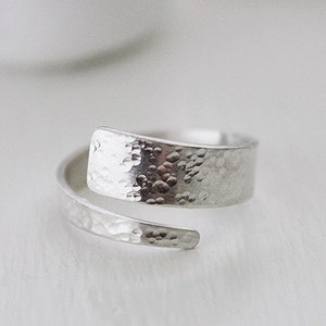 May include: A silver hammered metal ring with a unique twist design.