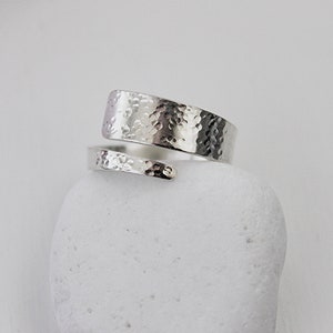 May include: A silver hammered wrap ring with a textured finish.