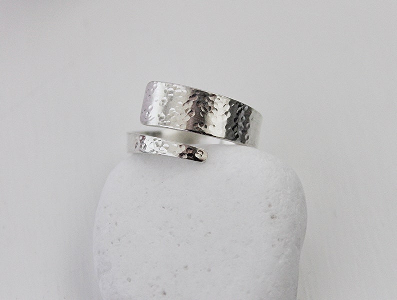 May include: A silver hammered wrap ring with a textured finish.