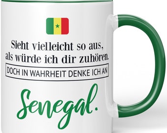 JUNIWORDS Tasse "Sieht vielleicht so aus, als würde ich dir zuhören. Doch in Wahrheit denke ich an Senegal." - 100 % Made in Germany