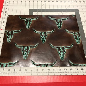 May include: Brown leather with a repeating pattern of turquoise embossed bull skulls.