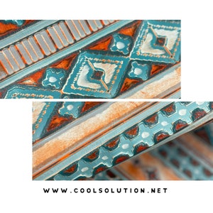 May include: Close-up of a wooden surface with a geometric pattern painted in shades of blue, orange, and white. The pattern features diamonds, stars, and lines.