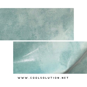 May include: A close-up of a light blue, textured, fabric surface. The fabric has a subtle sheen and a slightly uneven texture.