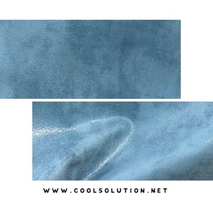 May include: Close-up of a light blue textured fabric. The fabric has a slightly grainy appearance and a subtle sheen.
