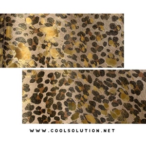 May include: Close-up of a brown and gold animal print fabric with a leopard pattern. The fabric has a metallic sheen and is perfect for upholstery or crafting projects.