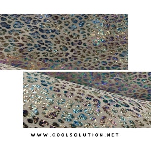 May include: White fabric with a holographic iridescent leopard print. The fabric has a subtle sparkle and shimmer.