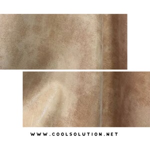 May include: Close-up of a light brown suede fabric with a subtle texture. The fabric has a seam running vertically down the center.