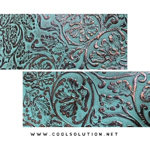 May include: Close-up of a teal blue and copper embossed leather fabric with a floral pattern. The fabric has a distressed look and is perfect for upholstery or crafting projects.