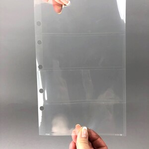 May include: Clear plastic page protector with four horizontal pockets for holding cards or other small items. The page has three rows of holes along the left edge for use in a binder. The page is labeled "17228" and "U.S.A."