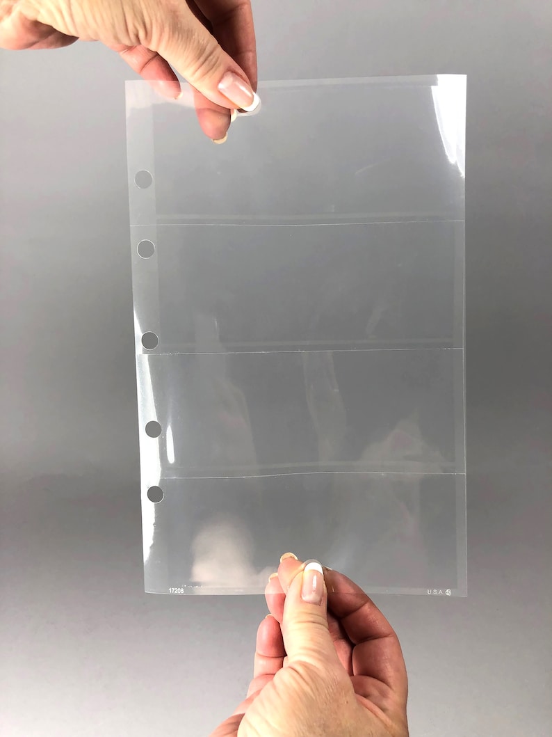 May include: Clear plastic page protector with four horizontal pockets for holding cards or other small items. The page has three rows of holes along the left edge for use in a binder. The page is labeled "17228" and "U.S.A."