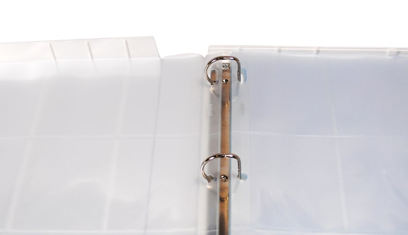May include: A white plastic binder with two silver rings. The binder is open and the pages are blank.